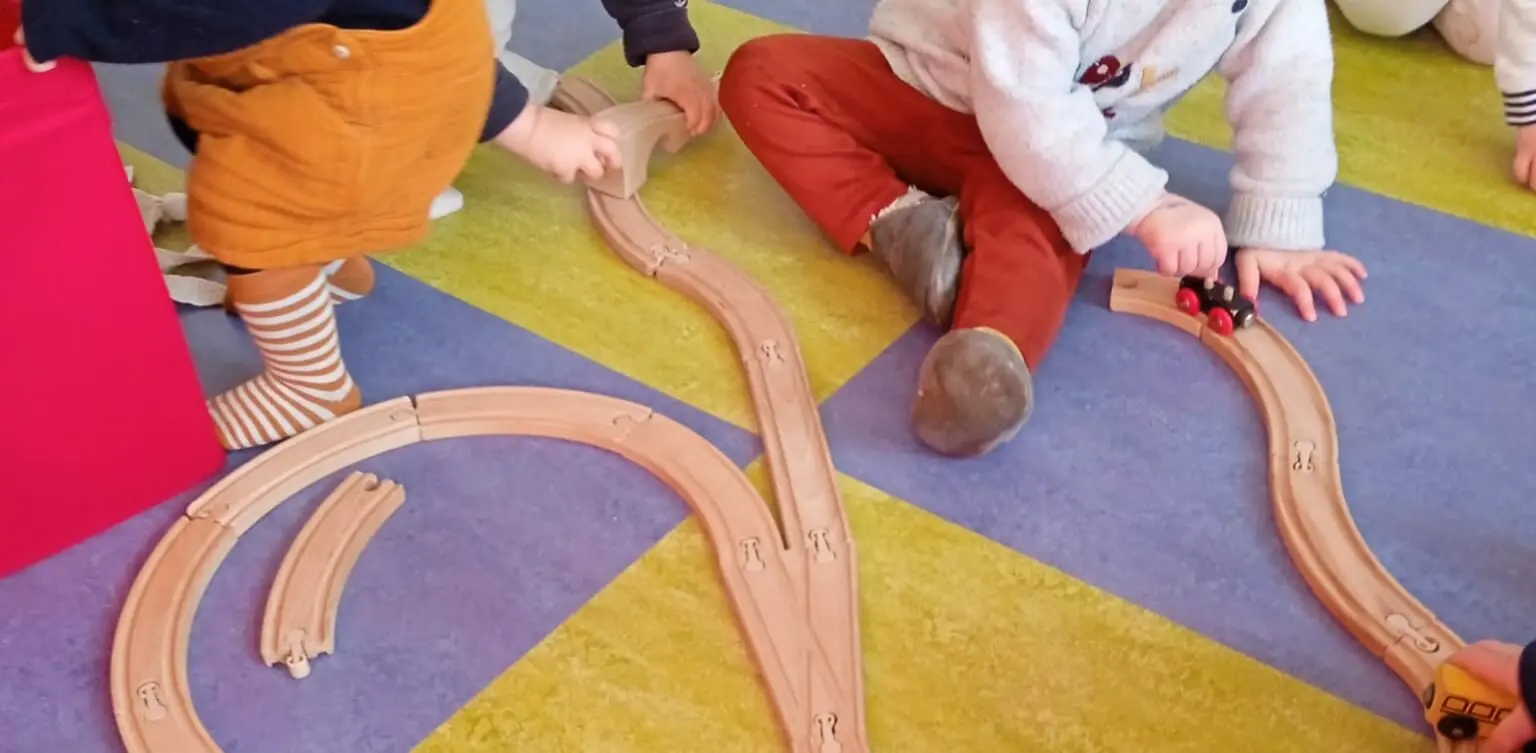 Mains d’enfants réunies autour d’une activité sur un tapis coloré